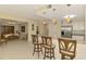 Open kitchen featuring stainless steel appliances, white cabinets, breakfast bar with stools, and seamless flow to dining area at 3433 Grand Vista Ct # 102, Port Charlotte, FL 33953