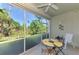 Enjoy the views from this screened lanai, furnished with a table and chairs and a ceiling fan at 3433 Grand Vista Ct # 102, Port Charlotte, FL 33953
