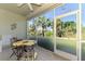 Enjoy the views from this screened lanai, furnished with a table and chairs and a ceiling fan at 3433 Grand Vista Ct # 102, Port Charlotte, FL 33953