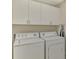 Functional laundry room with white washer and dryer units, and white cabinets above for storage at 3433 Grand Vista Ct # 102, Port Charlotte, FL 33953