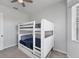 Bedroom with bunk beds with blue bedding, a ceiling fan, light grey walls and carpet with a view to the outside at 39 Fairway Rd, Rotonda West, FL 33947