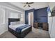 Bedroom with navy accent wall and built in desk, dark wood bed frame, light carpet and a ceiling fan at 39 Fairway Rd, Rotonda West, FL 33947