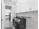 Bright laundry room with modern black washer and dryer set and ample overhead cabinet space at 39 Fairway Rd, Rotonda West, FL 33947