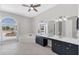 Bright primary bathroom with a large vanity, soaking tub, and a large arched window at 39 Fairway Rd, Rotonda West, FL 33947