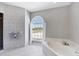 Bright main bathroom features a shower and soaking tub under a large arched window at 39 Fairway Rd, Rotonda West, FL 33947
