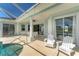 Covered patio with outdoor chairs, and glass sliding doors with view of pool at 39 Fairway Rd, Rotonda West, FL 33947