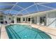 Back of house featuring a pool inside screened enclosure, glass sliding doors, with lounge chairs for relaxing by the water at 39 Fairway Rd, Rotonda West, FL 33947