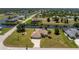 Expansive aerial view of a well-manicured property with a spacious lawn, waterfront access, and a tranquil setting in a residential area at 4 Pine Valley Ln, Rotonda West, FL 33947