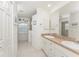 Bright bathroom featuring double sinks, white cabinetry, and a walk-in shower at 4 Pine Valley Ln, Rotonda West, FL 33947