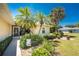 Charming front yard featuring lush landscaping, mature palm trees, and a welcoming entrance, creating a warm and inviting curb appeal at 4 Pine Valley Ln, Rotonda West, FL 33947