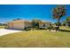 Well-maintained home featuring a three-car garage, beautiful landscaping, and a lush green lawn at 4 Pine Valley Ln, Rotonda West, FL 33947