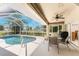 Relaxing screened-in pool and patio area with a ceiling fan, perfect for outdoor dining and enjoying the Florida weather at 4 Pine Valley Ln, Rotonda West, FL 33947