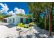 Charming backyard with white gravel, tropical trees and plants, and outdoor seating area at 4065 N Beach Rd # A, Englewood, FL 34223
