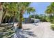 A beautifully landscaped backyard featuring lush palms and a screened-in pool area at 4065 N Beach Rd # A, Englewood, FL 34223