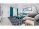 Cozy living room with a stylish gray couch, bright turquoise accents, and plenty of natural light at 4065 N Beach Rd # A, Englewood, FL 34223