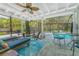Outdoor living space boasts a screened pool, ceiling fan, and seating areas, perfect for relaxation at 4065 N Beach Rd # A, Englewood, FL 34223