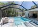 Inviting private pool surrounded by a screened enclosure, chaise lounges, and lush landscaping at 4065 N Beach Rd # A, Englewood, FL 34223