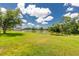 Expansive backyard with lush green grass and a tranquil lake, offering serene views and a sense of natural beauty at 4207 Fairway Pl, North Port, FL 34287