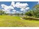 Picturesque backyard featuring a serene lake, lush green lawn, and a mature tree line, perfect for peaceful relaxation and outdoor activities at 4207 Fairway Pl, North Port, FL 34287