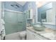 Bright bathroom with a glass bowl sink, tub with glass doors, and marble countertops offers a refreshing and stylish design at 4207 Fairway Pl, North Port, FL 34287