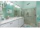 Updated bathroom with double sinks, white vanity, marble countertop, large mirror, and glass-enclosed shower at 4207 Fairway Pl, North Port, FL 34287