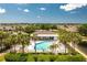 Beautiful community pool and clubhouse surrounded by lush landscaping, palm trees, and comfortable lounge chairs at 4207 Fairway Pl, North Port, FL 34287
