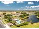 Community pool and clubhouse overlooking a scenic lake, surrounded by trees and well-maintained landscaping at 4207 Fairway Pl, North Port, FL 34287