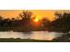 Waterfront homes bathed in a golden sunset glow, with lush greenery and tranquil water views at 4207 Fairway Pl, North Port, FL 34287