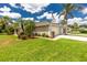 Charming single-story home featuring a well-maintained lawn, lush tropical landscaping, and an attached two-car garage at 4207 Fairway Pl, North Port, FL 34287