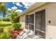 Inviting front porch featuring a screen door entry, tiled floor and decorative landscaping surrounding the entryway at 4207 Fairway Pl, North Port, FL 34287