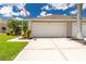 Beige two-car garage with an American flag, landscaping, and a spacious concrete driveway on a sunny day at 4207 Fairway Pl, North Port, FL 34287