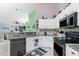 Bright kitchen featuring white cabinetry, granite countertops, and stainless steel appliances at 4207 Fairway Pl, North Port, FL 34287
