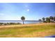 Scenic backyard featuring lush green grass, palm trees, and peaceful waterfront views at 4410 Warren Ave # 104, Port Charlotte, FL 33953
