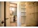Well-lit bathroom and walk-in closet with modern fixtures and ample shelving for optimal storage at 4410 Warren Ave # 104, Port Charlotte, FL 33953