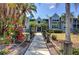 Charming condominium building with a serene walkway surrounded by lush tropical landscaping and flowers at 4410 Warren Ave # 104, Port Charlotte, FL 33953