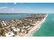 Beautiful aerial view showcasing beachfront homes along the coast with clear turquoise water and sunny skies at 5030 N Beach Rd # 1, Englewood, FL 34223