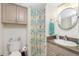 Cozy bathroom featuring neutral colors, a round mirror, and a shower with a patterned curtain at 5030 N Beach Rd # 1, Englewood, FL 34223