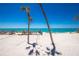 Beautiful beachside view of the home with lush palm trees and the sparkling ocean at 5030 N Beach Rd # 1, Englewood, FL 34223