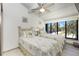 Bright bedroom featuring two twin beds, ceiling fan, and large windows with outdoor views at 5030 N Beach Rd # 1, Englewood, FL 34223