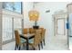 Light-filled dining room boasts a modern chandelier and a glass-top table with seating for six at 5030 N Beach Rd # 1, Englewood, FL 34223