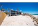 Exterior view of beachfront property with balconies, palm trees, and beach access at 5030 N Beach Rd # 1, Englewood, FL 34223
