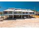Beach house exterior featuring a metal roof and covered parking at 5030 N Beach Rd # 1, Englewood, FL 34223