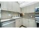 Well-maintained kitchen with stainless steel dishwasher, sink, and tile backsplash at 5030 N Beach Rd # 1, Englewood, FL 34223
