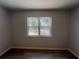 Empty bedroom with wood-look tile, neutral walls, and a window at 5417 Postma St, North Port, FL 34287