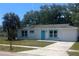 A well-maintained single story home featuring a bright turquoise front door, and a one-car garage at 5417 Postma St, North Port, FL 34287