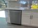 Modern kitchen features stainless steel dishwasher, white cabinets, and gray backsplash at 5417 Postma St, North Port, FL 34287