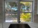 Picture perfect backyard view from the kitchen window. Featuring stainless steel sink, white cabinets and quartz countertop at 5417 Postma St, North Port, FL 34287