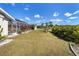 Expansive backyard with lush green lawn, mature trees, and screened-in patio, ideal for gatherings at 56 Long Meadow Ct, Rotonda West, FL 33947