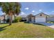 Charming single-story home with lush lawn, mature trees, and a two-car garage at 56 Long Meadow Ct, Rotonda West, FL 33947