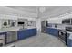 Bright kitchen featuring blue cabinets, stainless steel appliances, and views into the living room at 56 Long Meadow Ct, Rotonda West, FL 33947